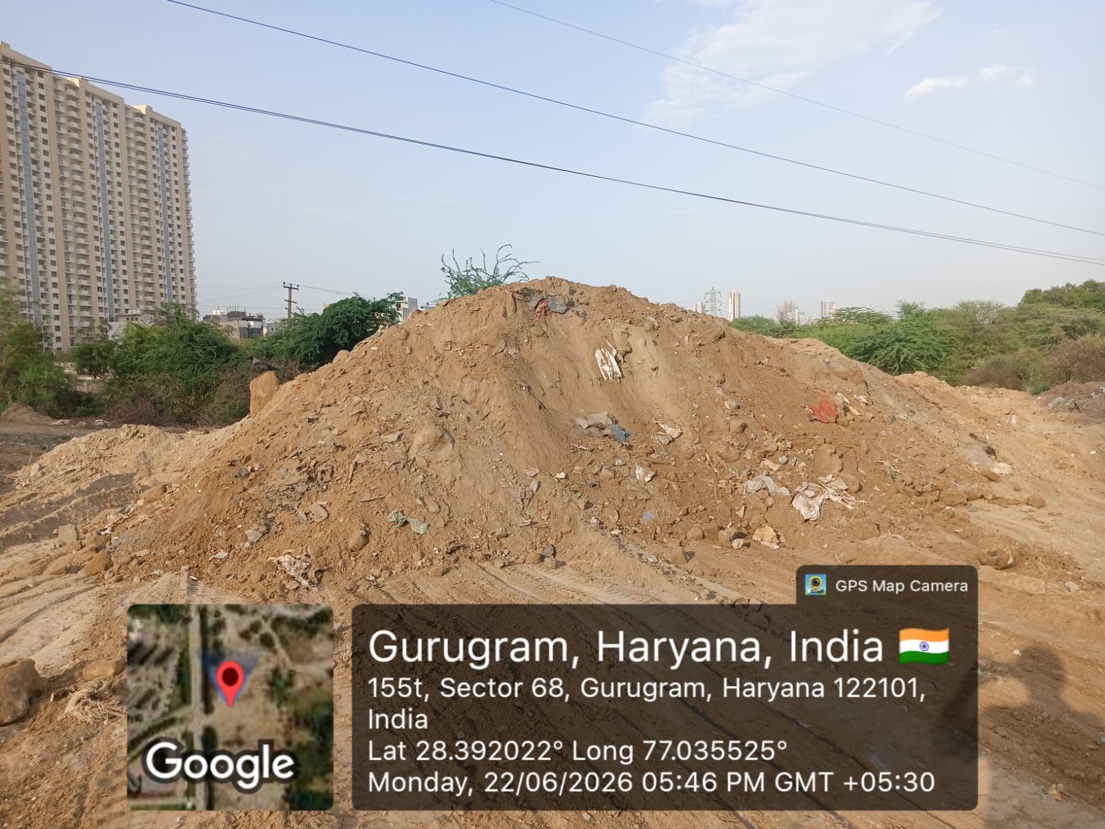A large heap of excavated soil mixed with plastic and rubble