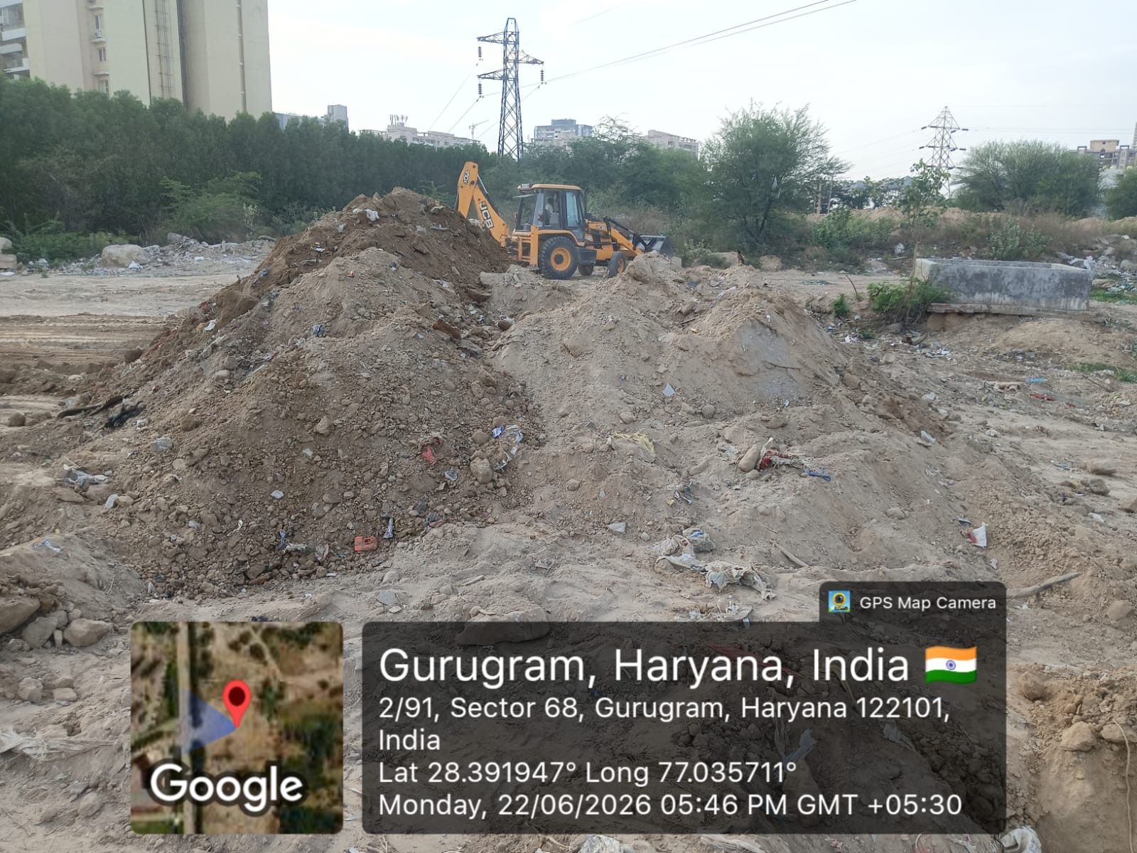 Heaps of excavated soil with a backhoe loader working behind them