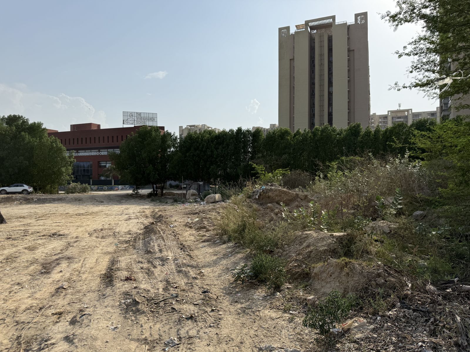 The edge of the site, with a school building and a residential tower behind