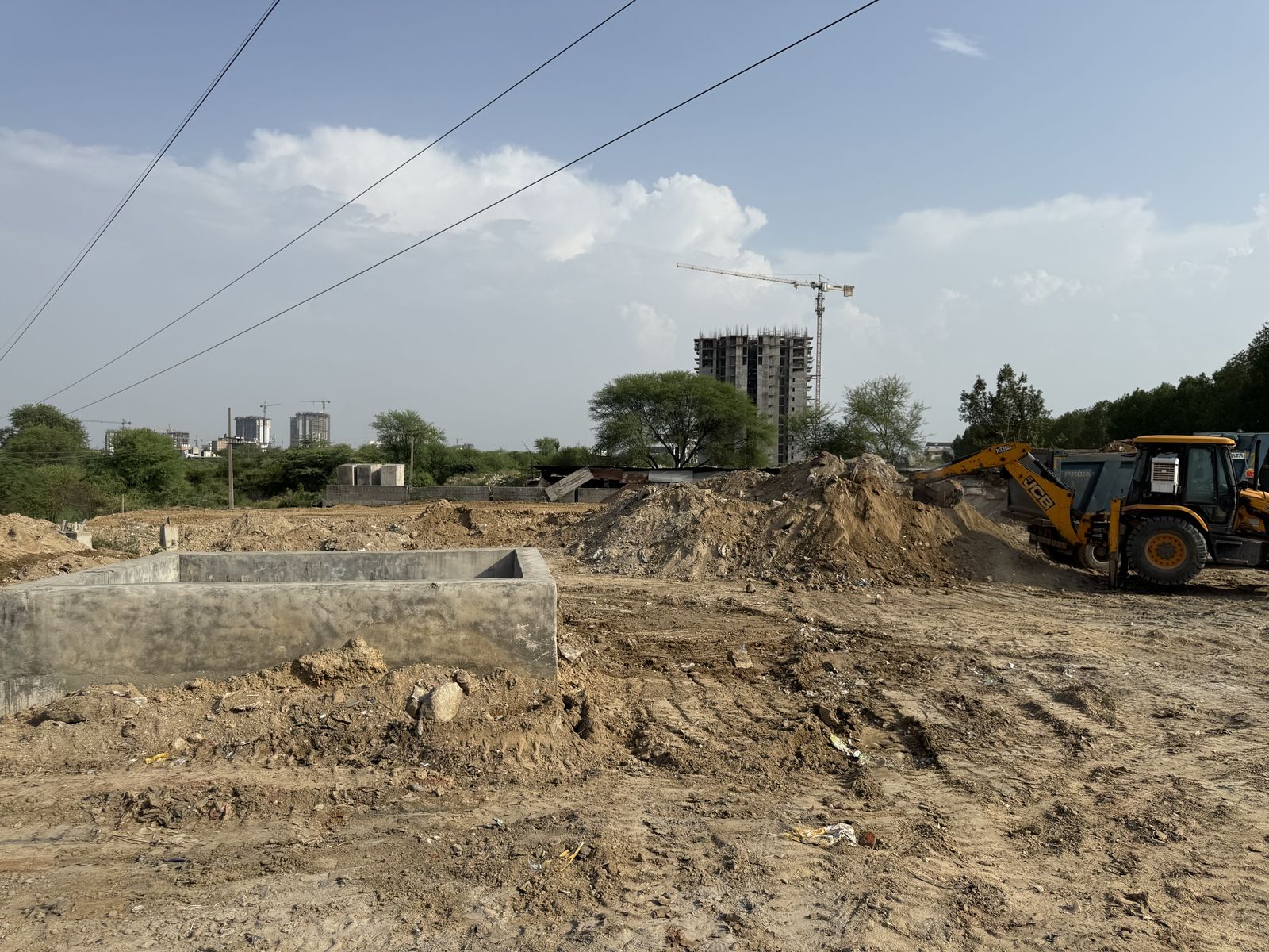 Excavated soil heaped beside a backhoe loader